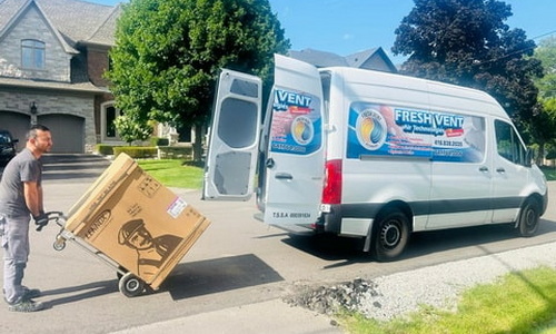 FreshVent service van parked in a residential area, with a technician unloading an HVAC system.